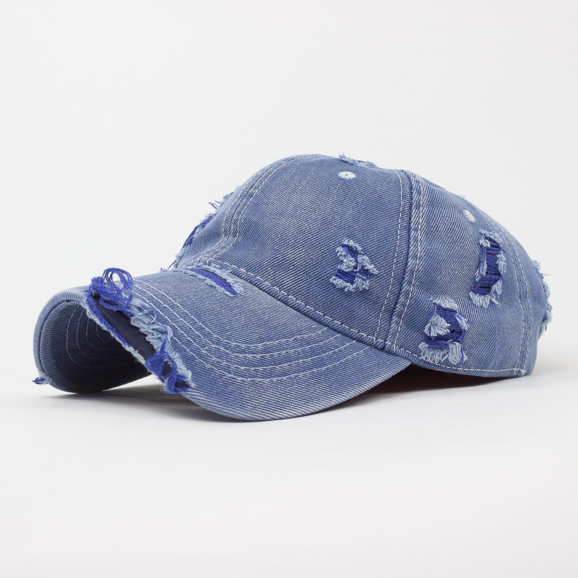 Blue denim cap with distressed details on a white background