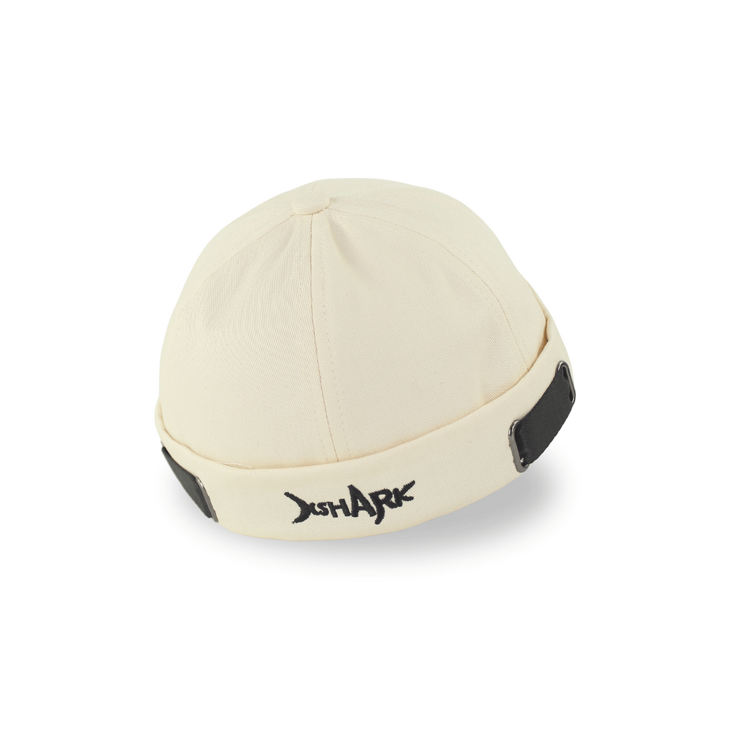 Profile view of a premium off-white brimless docker hat for men with black embroidery and adjustable side straps