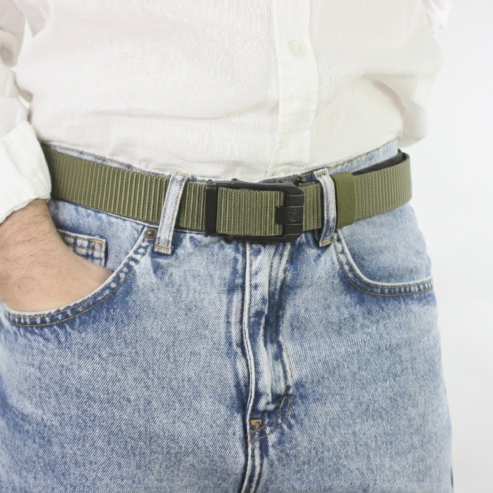 A close-up view of a man wearing a green web belt with a black sliding buckle, paired with a white shirt and light blue denim jeans.